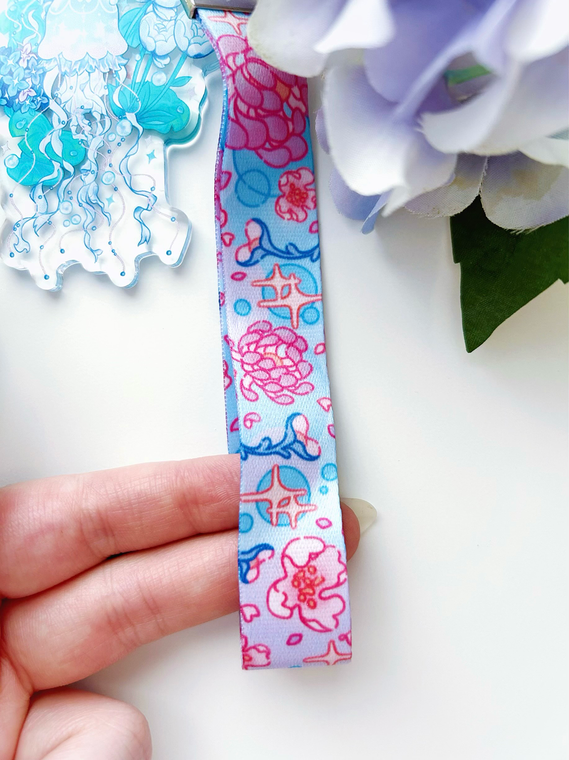 An acrylic lanyard keychain featuring a Jellyfish Garden concept