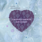 A monthly affirmation card featuring a dark purple heart-shaped card with a key pattern, set against a light blue lace background with small star illustrations.