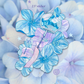 A decorative sticker design featuring blue and lavender flowers with a small wind chime and stars, shown over a soft background of pale blue hydrangea-like petals.